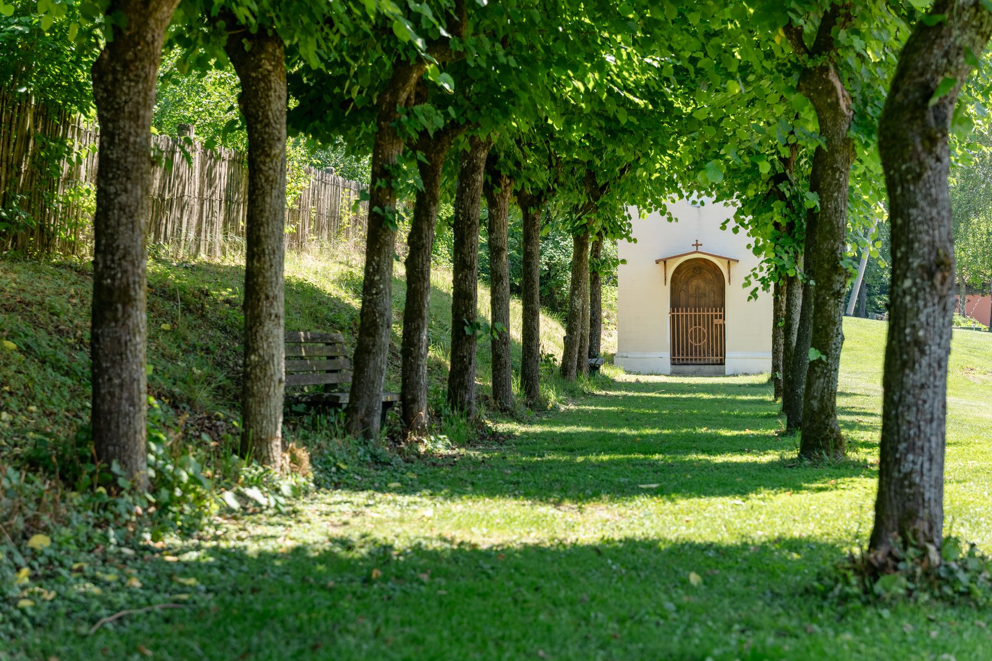 Baumallee mit Kapelle im Garten