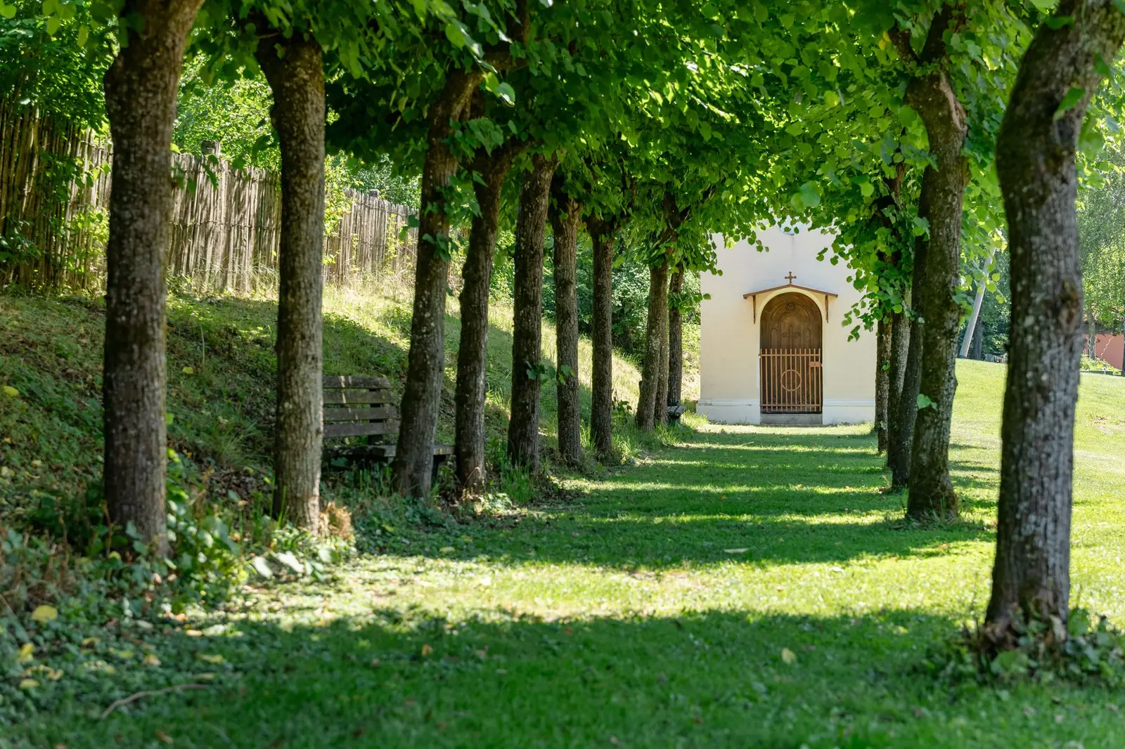 Baumallee mit Kapelle im Garten